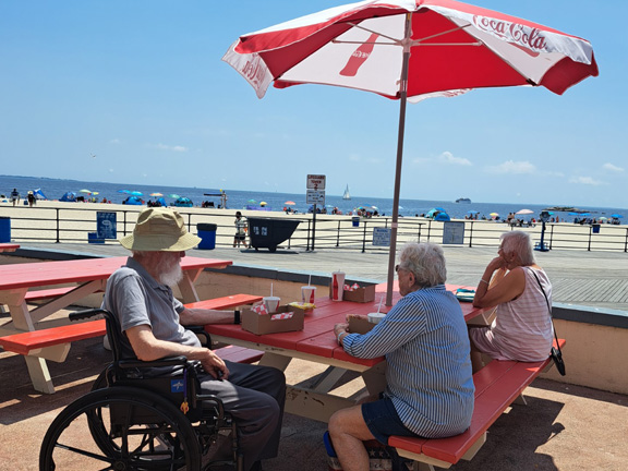 seniors at beach under umbrella